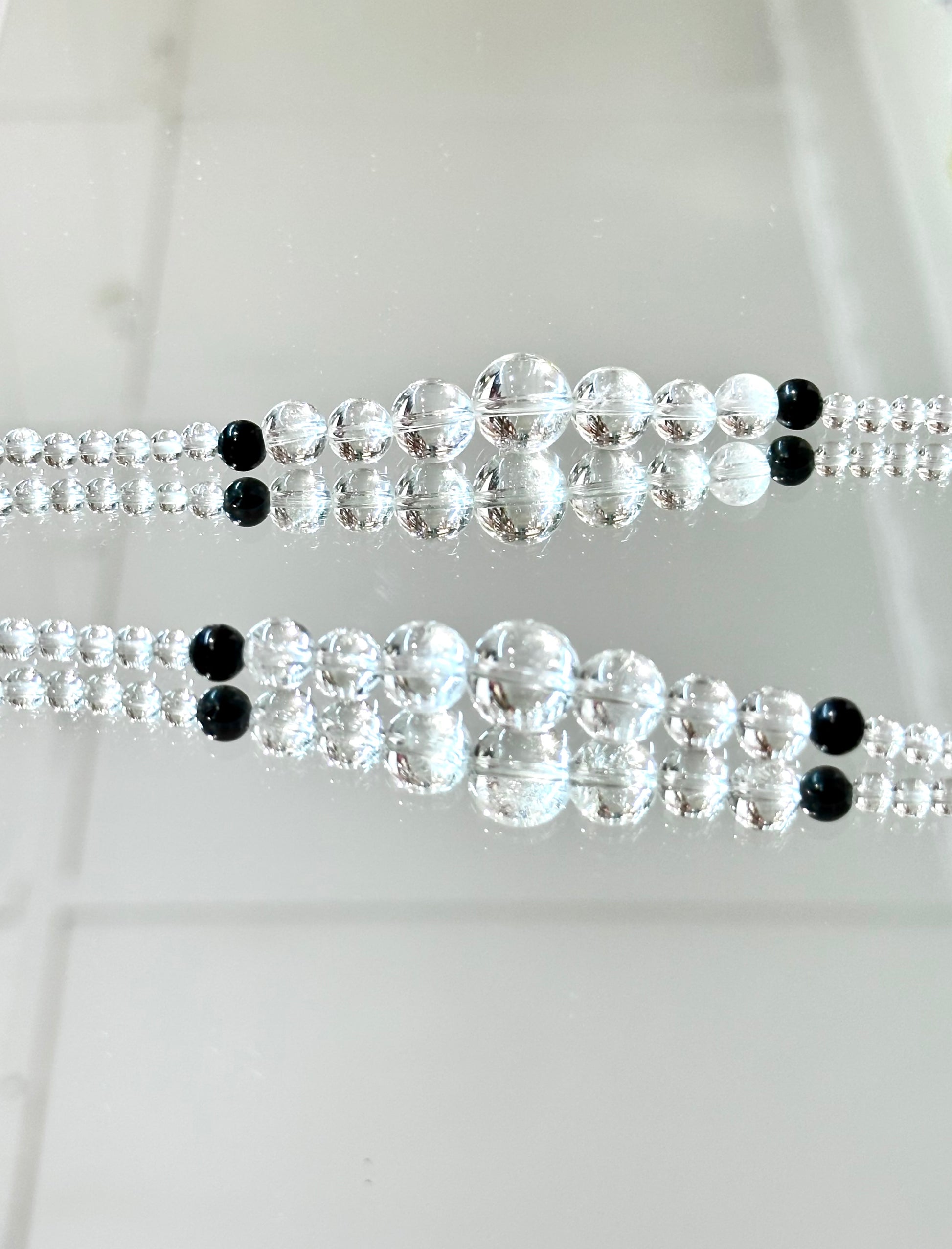 Two crystal beaded belts with black beads on a white background