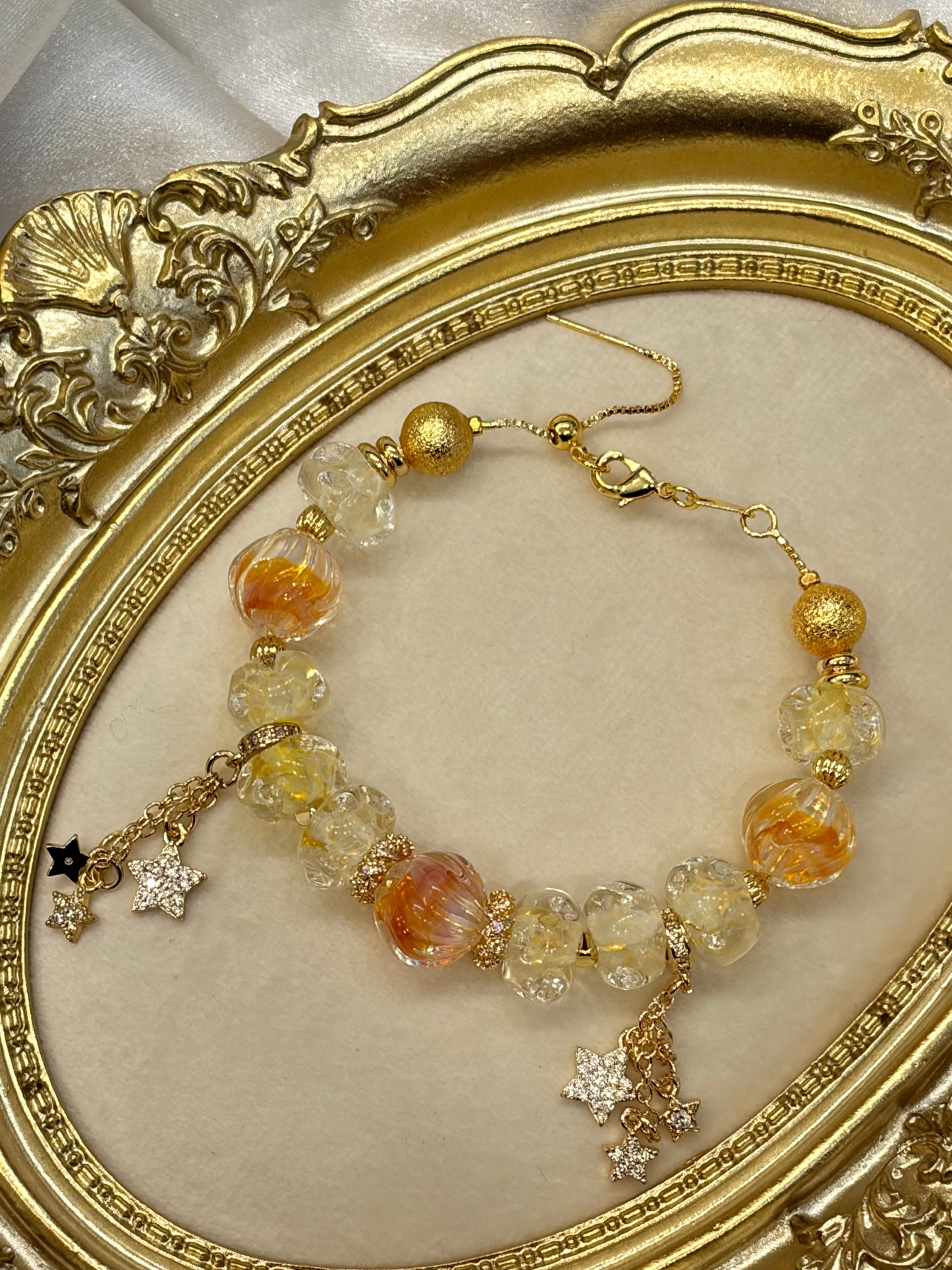 Close-up of amber and clear floral glass beads with gold textured accent beads