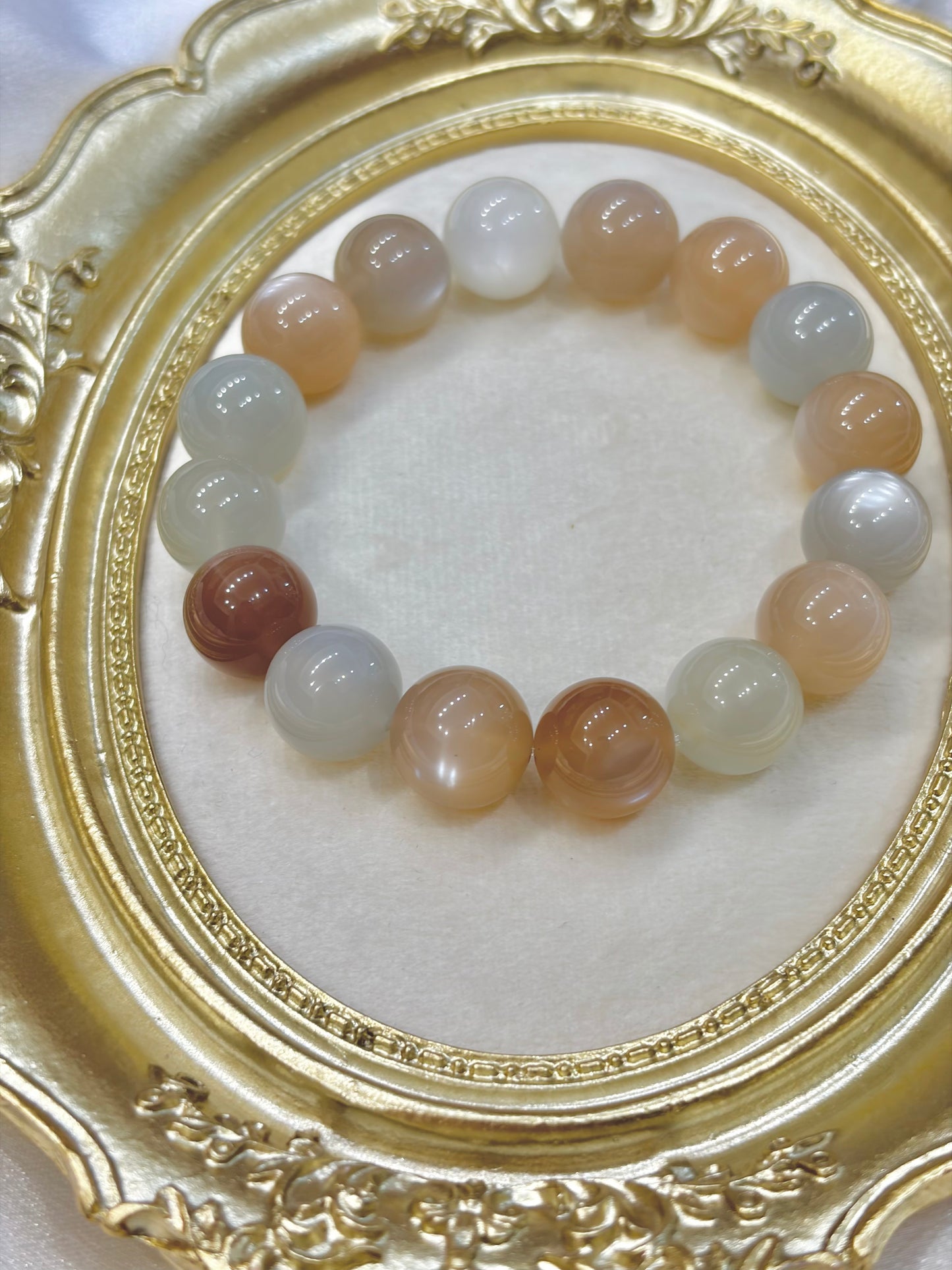 Multicolored beaded bracelet on a white surface with a gold decorative frame.